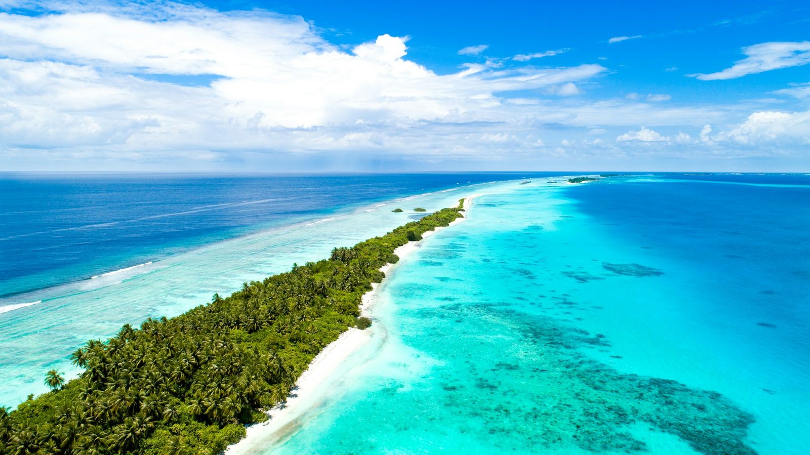 Aerial view of a Maldives island reef and turquoise lagoon