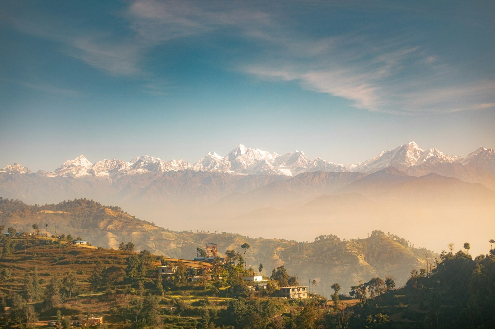 Snow-capped Himalayan peaks above a misty valley in Nepal
